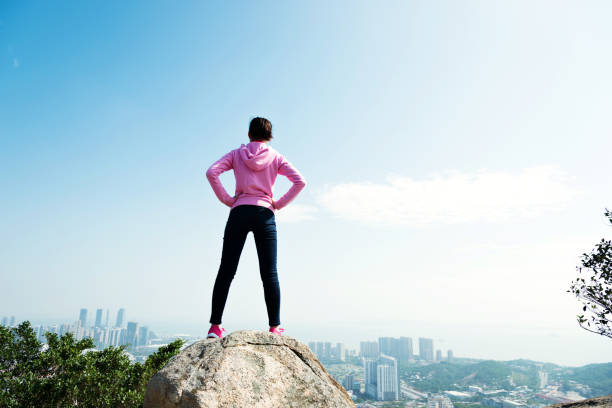 istock Woman standing on the mountain peak rock 847225982