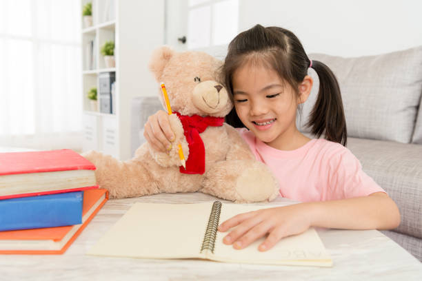 istock smiling little girl doing homework with her teddy 847226136