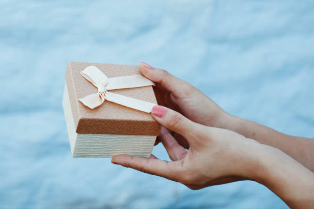 istock Woman hand holding brown gift box 847227168