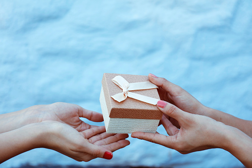 Closeup hands giving and receiving gift box