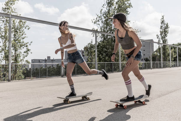 istock Young women skateboarding together 847237928
