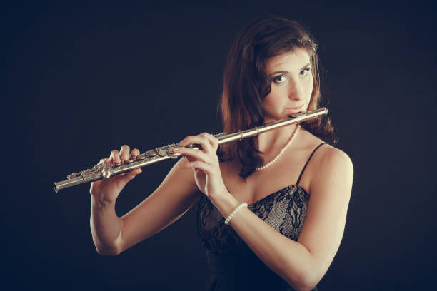 istock Woman playing transverse flute on black. 847241450