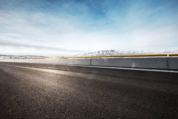 istock empty asphalt road with snow mountains in blue sky 847241506