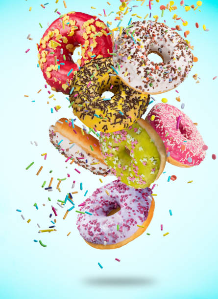 istock Tasty doughnuts in motion falling on pastel blue background 847243108