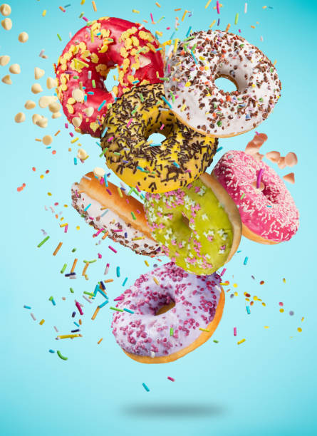 istock Tasty doughnuts in motion falling on pastel blue background 847244174
