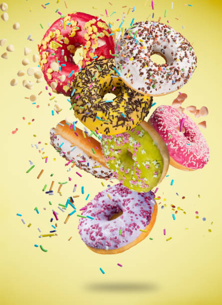 istock Tasty doughnuts in motion falling on pastel yellow background 847247494