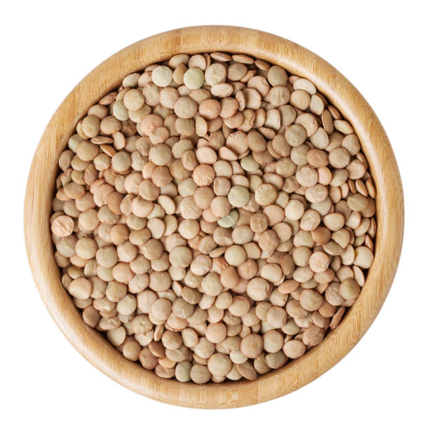 istock Uncooked lentils in wooden bowl isolated on white background with clipping path 847248524