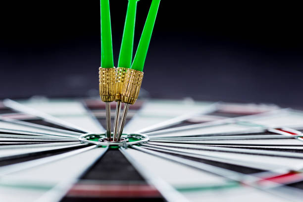 hitting the bulls eye on the black background - target aspirations bulls eye dart imagens e fotografias de stock