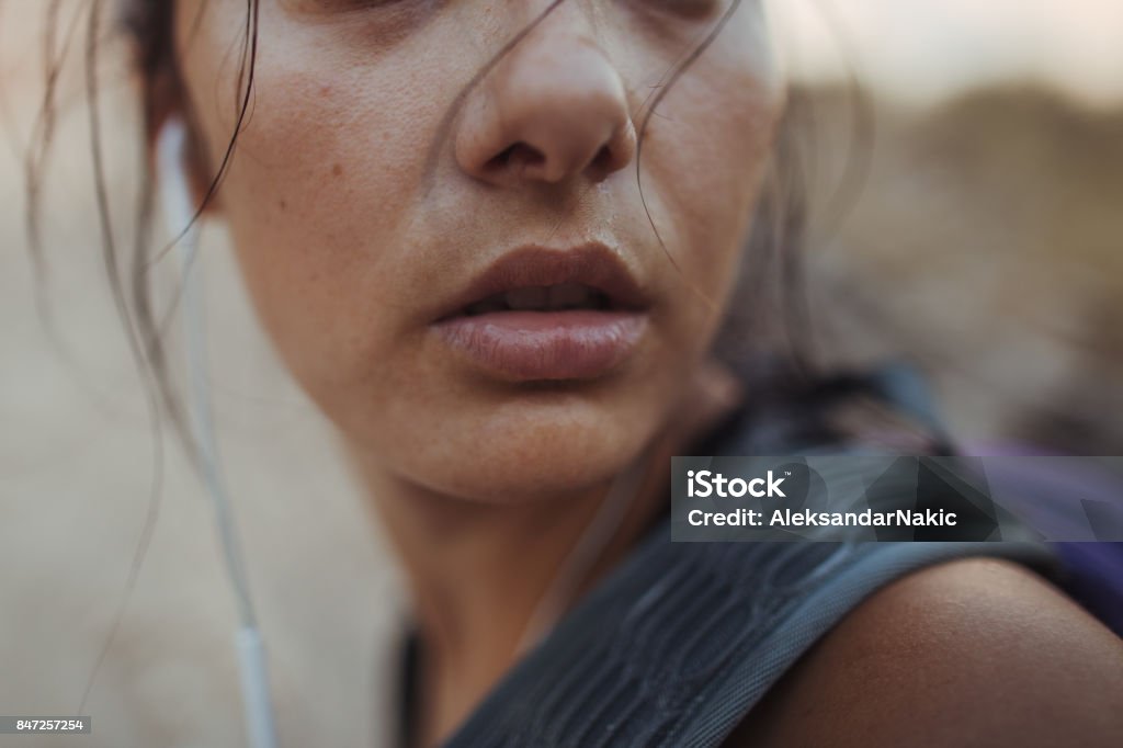 Gritty woman Photo of a young determined woman during her hike in the nature Running Stock Photo