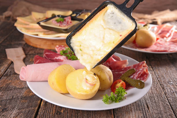 раклетт сыр расплавленный на картофеле - raclette cheese стоковые фото и изображения