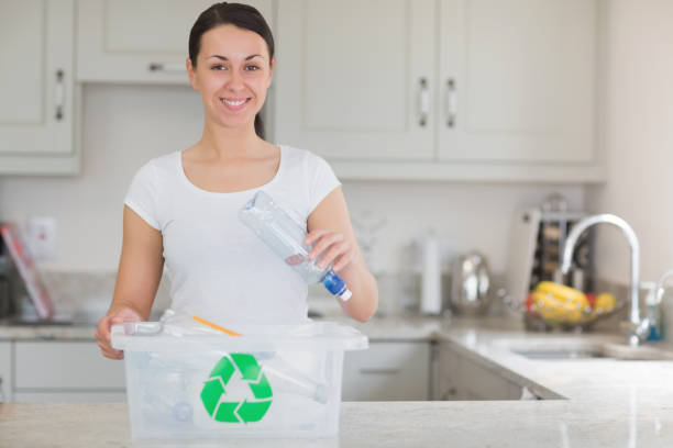 istock Woman throwing bottle into recycling bin 847260598
