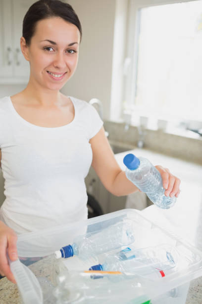 istock Woman throwing many bottles into recycling bin 847260740