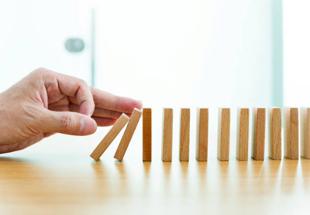 istock Man hand pushing domino pieces 847260742