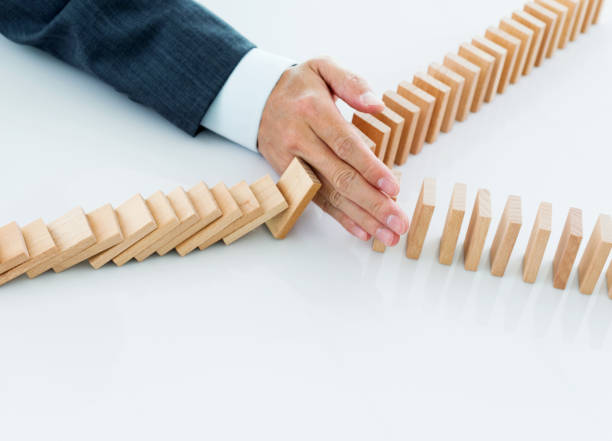 istock Businessman hand stopping falling blocks on table 847261038
