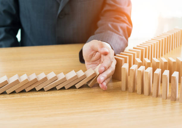 istock Businessman hand stopping falling blocks on table 847261040