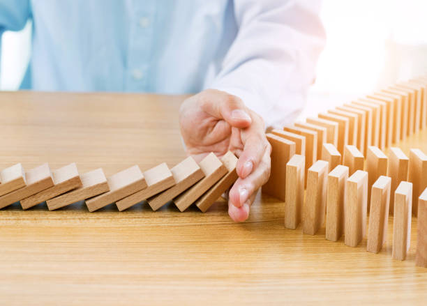 istock Businessman hand stopping falling blocks on table 847261110