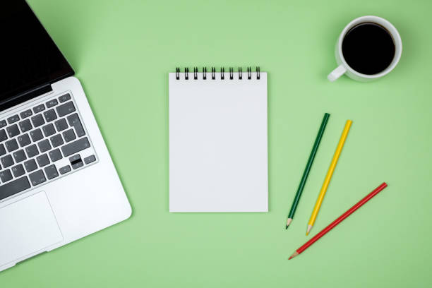 istock Modern green office desk table with laptop and blank notebook page for input the text. Top view, flat lay 847261614
