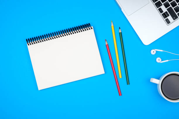 istock Minimal workplace with laptop and blank notepad on colored background. Top view. Flat lay 847261620