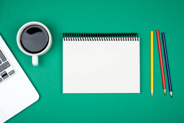 istock Modern designer office desk table with blank notebook page, laptop computer and cup of coffee. Top view, flat lay 847261748