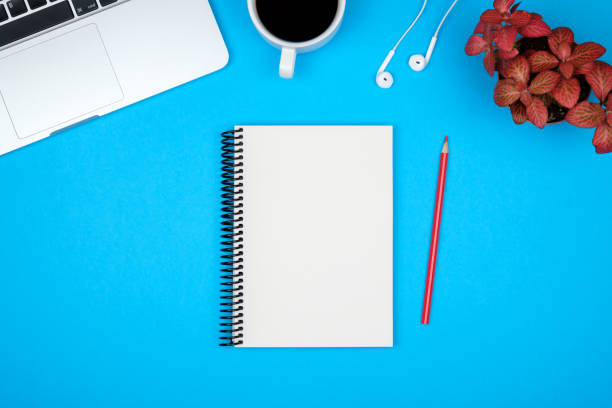 istock Minimal workplace with laptop and blank notepad on colored background. Top view. Flat lay 847261828
