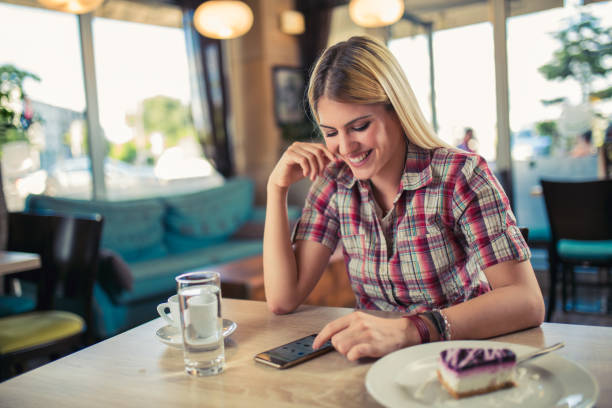 istock Attractive young woman using mobile phone in modern cafe 847269050