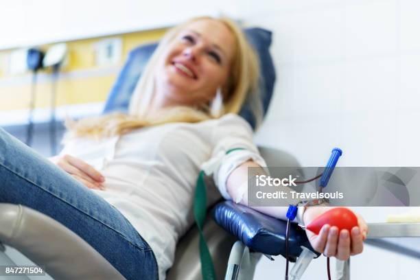 Young Caucasian Woman With Toy Heart In The Hand Donates Blood For Saving Lives And Medical Research Stock Photo - Download Image Now