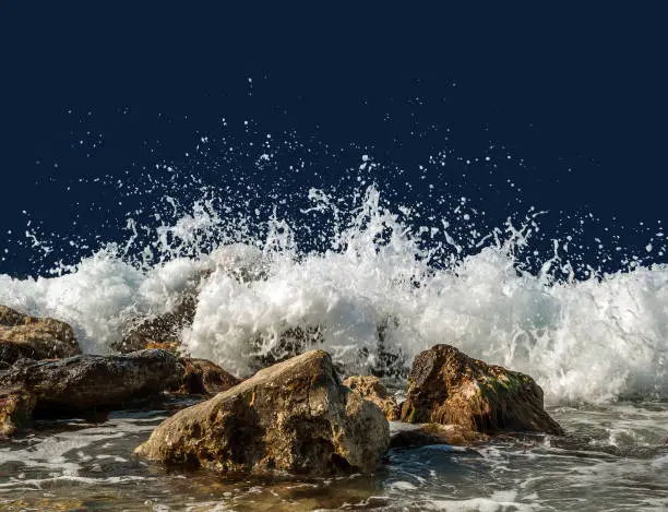 Splashing sea water on rocks isolated on a dark blue background