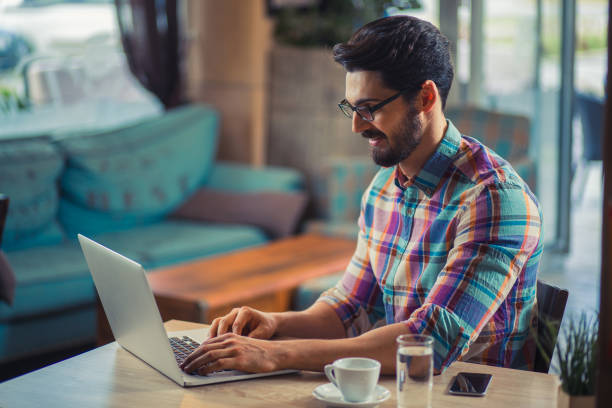 istock Young  casual man using laptop in modern cafe 847271984