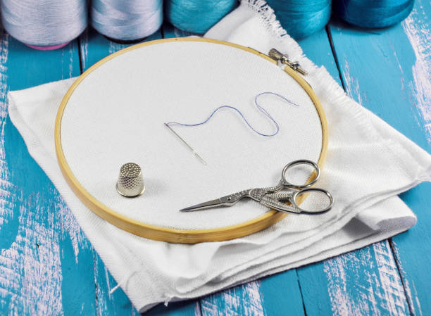 rond de tissu blanc pour le volley en broderie en bois avec des bobines de fil bleu - embroidery cross stitch needle sewing photos et images de collection