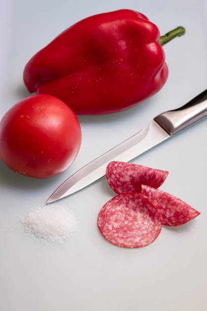 Slices salami with vegetables and salt.
