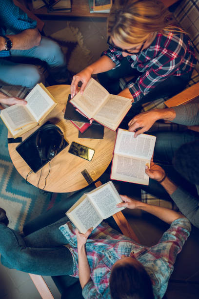 istock Diverse group of friends discussing a book in library. 847277410