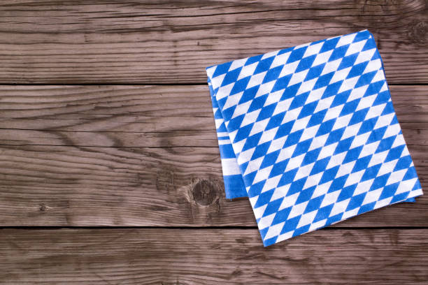 Bavarian white and blue napkin on old wooden table. Beer Fest background