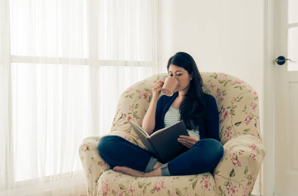istock beauty girl drinking hot coffee and reading book 847280086