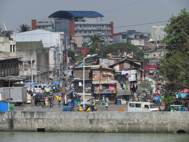 Street view in poor neighborhood in Manila Manila Philippines, 10 February 2015: Street view in poor neighborhood in Manila with people walking in the street jakarta slums stock pictures, royalty-free photos & images