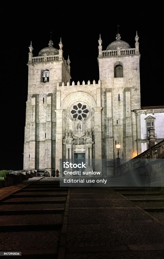 Night shot of Porto's Cathedral in Porto, Portugal PORTO, PORTUGAL - MARCH 12, 2017: Porto cathedral illuminated facade and staircase at night. This religious Christian Catholic temple mixes romanesque, gothic and baroque architecture. Architecture Stock Photo