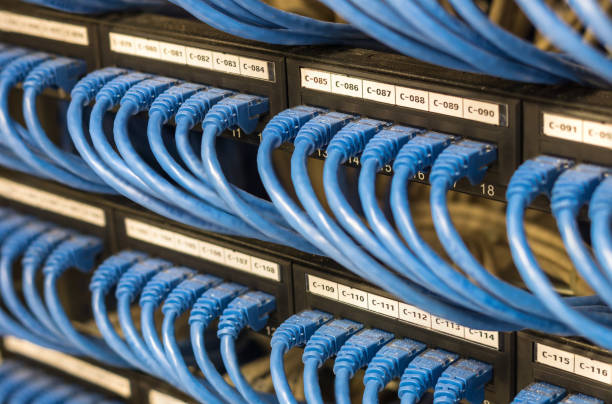 ряды сетевого кабеля, подключенного к маршрутизатору и концентратору коммутатора в серверном зале - контактировать с линзой стоковые фото и изображения