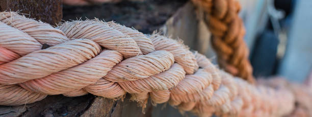 ropes on old rusty ship closeup. old frayed boat rope as a nautical background. naval ropes on a pier. vintage nautical knots. big marine sea ship ropes. - wood yacht textured nautical vessel imagens e fotografias de stock