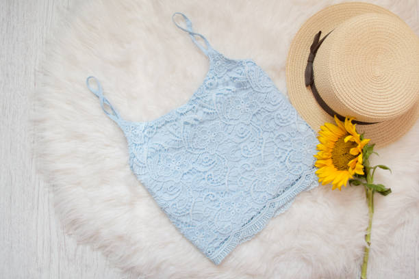 istock Blue lace top, straw hat and sunflower. On white fur, top view 847311224