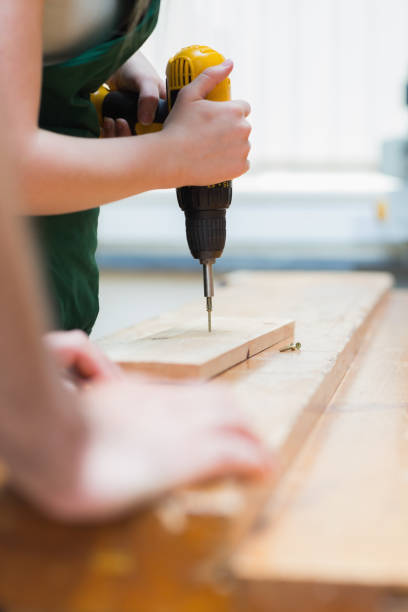 istock Drilling a hole in a wooden board on the workbench 847312468