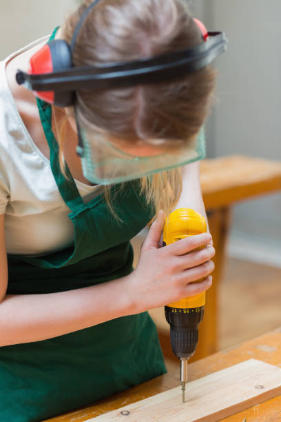istock Student drilling a hole in a wooden board at the workbench 847312522