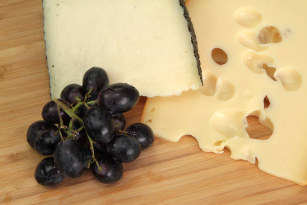 käse und trauben - cheese emmental cheese swiss culture cutting board stock-fotos und bilder