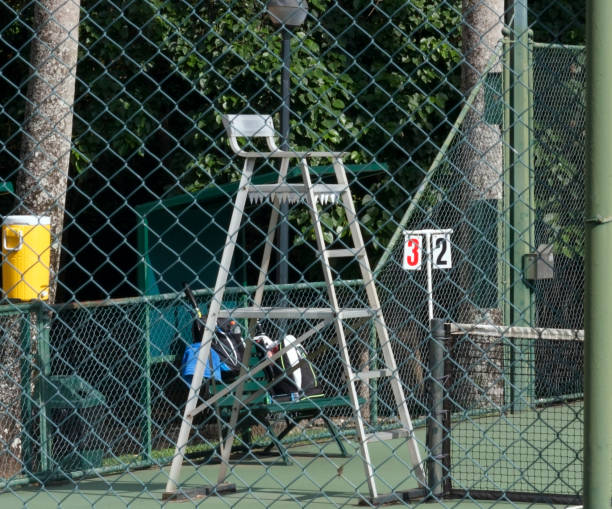 Tennis chair look through wire link fence 