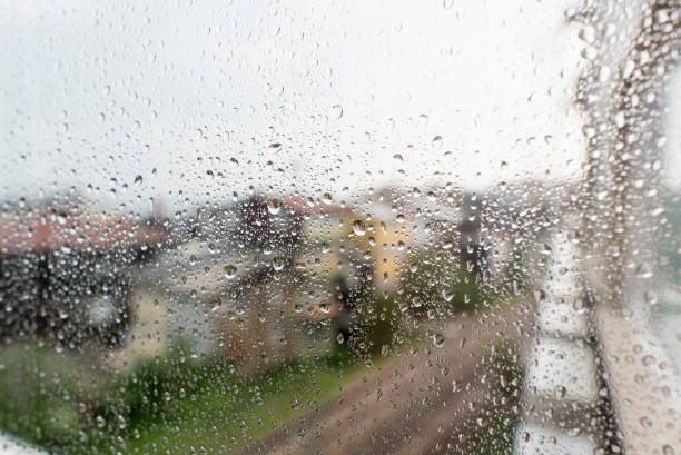 istock Rain drops on window glasses surface with city background. Natural Pattern of raindrops isolated on urban background 847326162