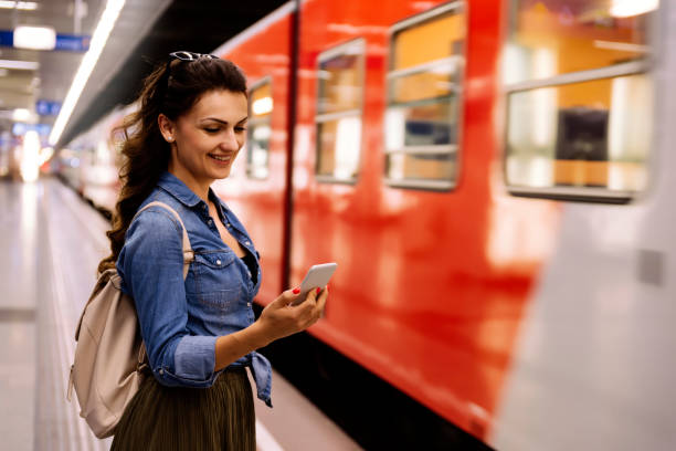 istock Beautiful woman using her cell phone on subway platform. 847326194