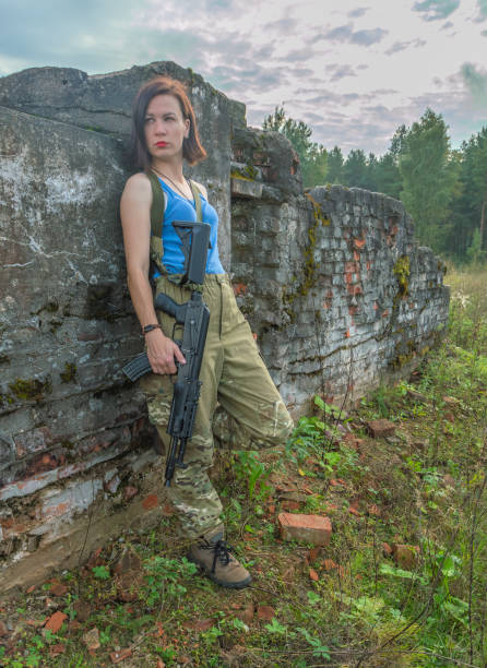istock girl with gun posing in a stone wall 847326308