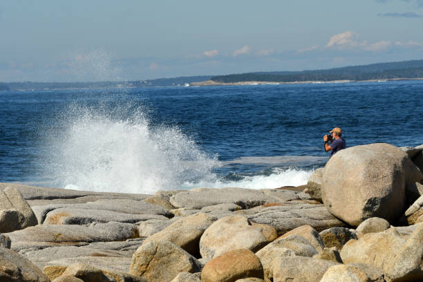 istock Senior Man taking Pictures at the Ocean (Cranberry Cove, Nova Scotia Canada) 847326344