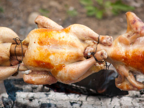 Grilled chickens Grilled chickens on skewer smoking meat rotisserie barbecue grill stock pictures, royalty-free photos & images