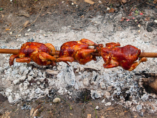 Grilled chickens Grilled chickens on skewer smoking meat rotisserie barbecue grill stock pictures, royalty-free photos & images
