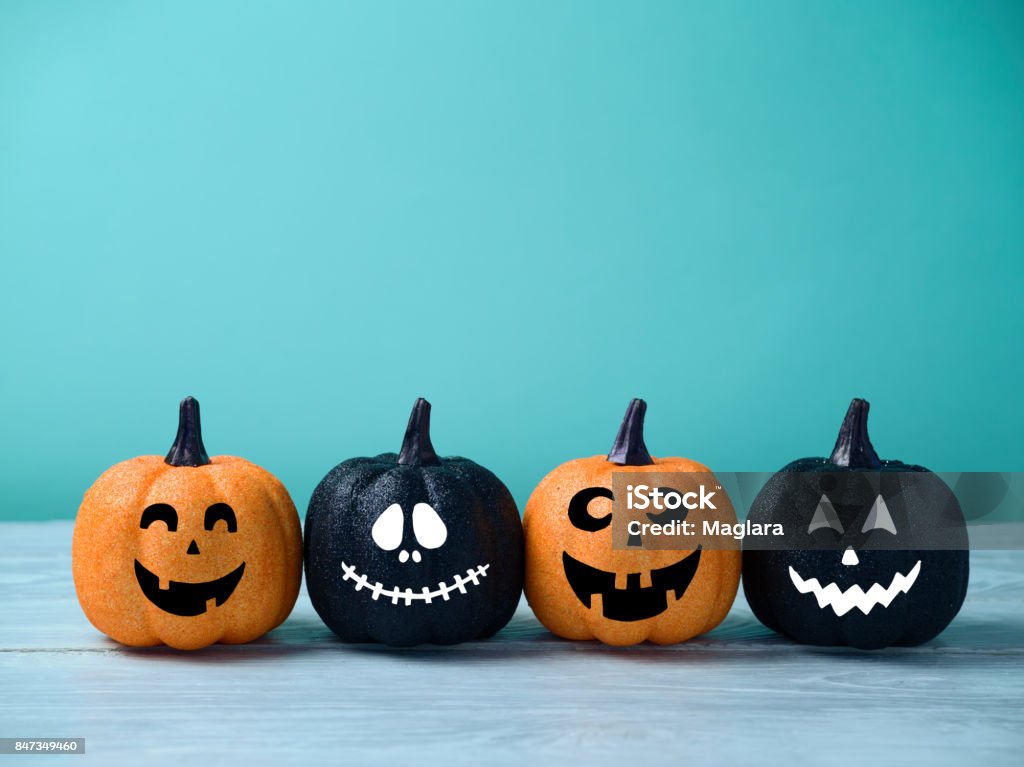 Halloween glitter pumpkin jack o lantern decor Halloween glitter pumpkin jack o lantern decor with funny faces. Halloween Stock Photo