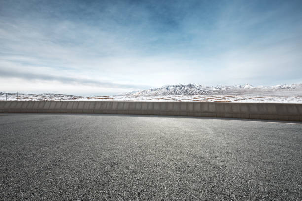 istock empty asphalt road with snow mountains in blue sky 847350820